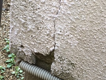 外壁がひび割れし、破損している様子