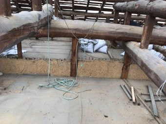 屋根の骨組以外を解体後、小屋裏の清掃をしている様子