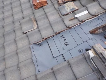 解体した屋根の上に防水シートを敷いた様子