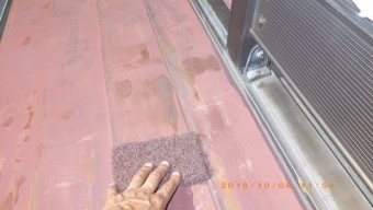 屋根の塗装工事の錆び掃除の様子