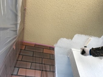 外壁に下塗りしている様子