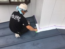 トタン屋根に錆止めを塗装する様子