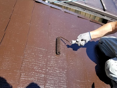 ひび割れたスレート屋根の塗装工事の様子
